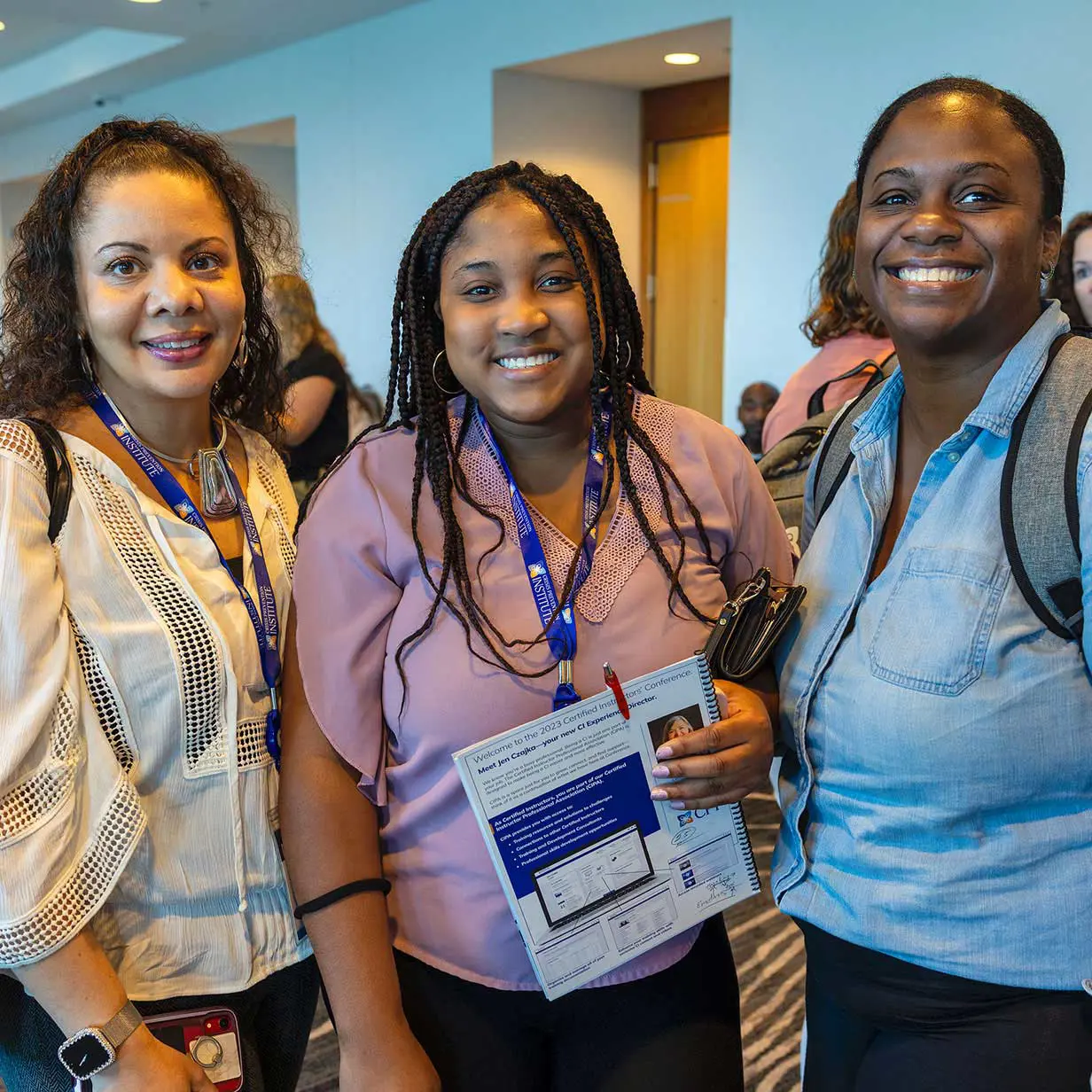 Three smiling women at a CPI training.