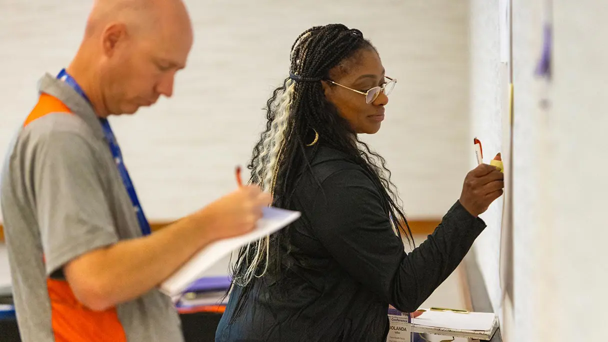 Man and a woman during training writing on a flip chart.