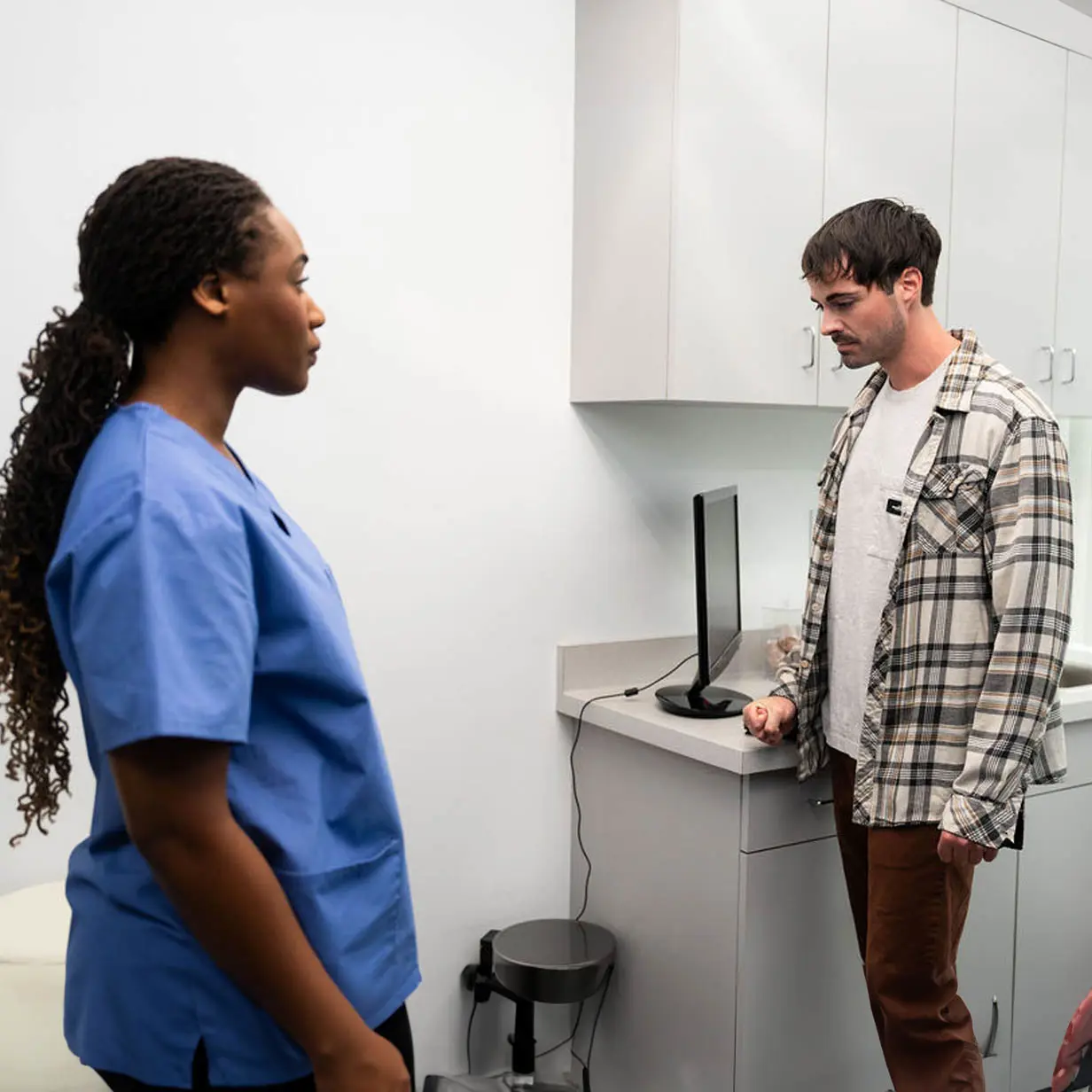 A medical professional talking to a distressed patient.