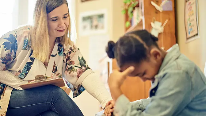 A woman consoling a young student.